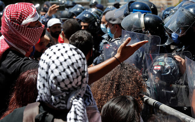 An anti-government protester argues with riot police during a protest against a general amnesty law being proposed in parliament in Beirut, Lebanon, May 28, 2020. (AP/Hussein Malla) An anti-government protester argues with riot police during a protest against a general amnesty law being proposed in parliament in Beirut, Lebanon, May 28, 2020. (AP/Hussein Malla)