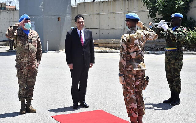 Lebanese Prime Minister Hassan Diab, center, stands next to the Head of Mission and Force Commander of the United Nations Interim Force in Lebanon, Major-General Stefano Del Col, left, as he reviews the honor guard of the United Nations peacekeepers in Naqoura, Lebanon, May 27, 2020. (Dalati Nohra via AP) Lebanese Prime Minister Hassan Diab, center, stands next to the Head of Mission and Force Commander of the United Nations Interim Force in Lebanon, Major-General Stefano Del Col, left, as he reviews the honor guard of the United Nations peacekeepers in Naqoura, Lebanon, May 27, 2020. (Dalati Nohra via AP)