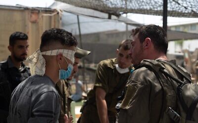 Israeli troops interrogate a Palestinian man as part of a manhunt for the person who threw a brick at Sgt. First Class Amit Ben-Ygal, killing him, in the West Bank village of Yabed on May 13, 2020. (Israel Defense Forces)
