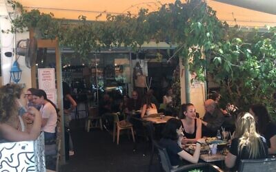 Young Tel Avivians at Cafe Zurik in Tel Aviv on the first day that restaurants were allowed to open after the coronavirus, May 27, 2020. (Simona Weinglass/Times of Israel)