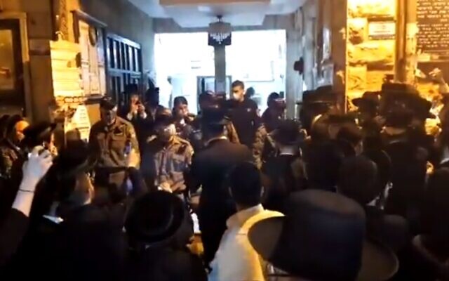 Dozens gather when police arrive to disperse a gathering in contravention of coronavirus regulations at synagogue in Jerusalem ultra-Orthodox neighborhood of Mea She'arim, May 15, 2020 (Screen grab/Kan) Dozens gather when police arrive to disperse a gathering in contravention of coronavirus regulations at synagogue in Jerusalem ultra-Orthodox neighborhood of Mea She'arim, May 15, 2020 (Screen grab/Kan)