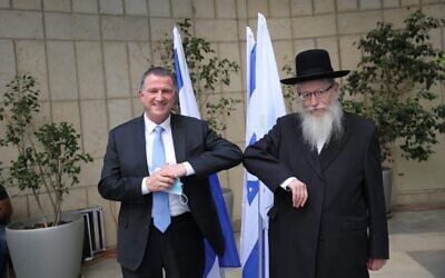 New Health Minister Yuli Edelstein (L) and outgoing Health Minister Yaakov Litzman at a passing of the baton ceremony at the Health Ministry on May 18, 2020. (Health Ministry)