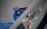 A health professional takes care of a patient at the Intensive Care Unit (ICU) ward where patients infected with the novel coronavirus, COVID-19, are being treated at the Doctor Ernesto Che Guevara Public Hospital in Marica city, state of Rio de Janeiro, Brazil, on June 5, 2020. (Mauro Pimentel / AFP)