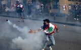 A Lebanese protester throws back a tear gas canister amid clashes with riot police following a demonstration in central Beirut, on June 6, 2020. (PATRICK BAZ / AFP)