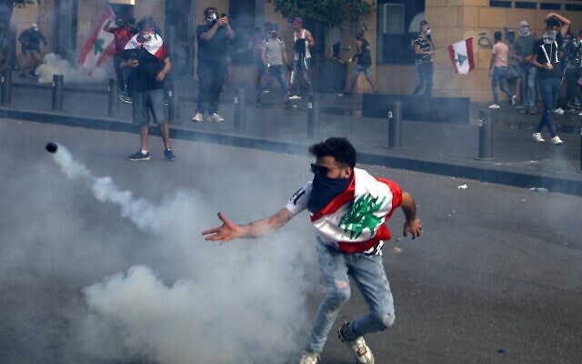 A Lebanese protester throws back a tear gas canister amid clashes with riot police following a demonstration in central Beirut, on June 6, 2020. (PATRICK BAZ / AFP) A Lebanese protester throws back a tear gas canister amid clashes with riot police following a demonstration in central Beirut, on June 6, 2020. (PATRICK BAZ / AFP)