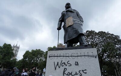 The statue of former British prime minister Winston Churchill is seen defaced, with the words (Churchill) 'was a racist' written on its base in Parliament Square, London, on June 7, 2020 (ISABEL INFANTES / AFP)