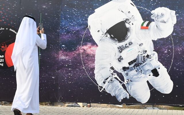 Illustrative -- In this file photo taken on September 25, 2019 a man takes a picture of an illustration depicting an astronaut with the Emirati national flag outside Mohammed Bin Rashid Space Centre (MBRSC) in Dubai (KARIM SAHIB / AFP) Illustrative -- In this file photo taken on September 25, 2019 a man takes a picture of an illustration depicting an astronaut with the Emirati national flag outside Mohammed Bin Rashid Space Centre (MBRSC) in Dubai (KARIM SAHIB / AFP)