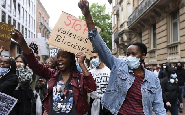 Demonstrators raise their fists past a placard reading 'Stop police brutality' in Toulouse, southern France, on June 10, 2020 (REMY GABALDA / AFP) Demonstrators raise their fists past a placard reading 'Stop police brutality' in Toulouse, southern France, on June 10, 2020 (REMY GABALDA / AFP)
