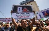 Palestinians lift placards during a protest against Israel's plans to annex parts of the West Bank, at Rafah in the southern Gaza Strip, on June 11, 2020. (Said Khatib/AFP)