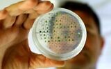 Iftach Yacoby, head of the Tel Aviv University's renewable energy laboratory, examines micro algae samples during research to demonstrate the evolutionary capacities of plants with the sun to produce energy on June 11, 2020. (JACK GUEZ / AFP)