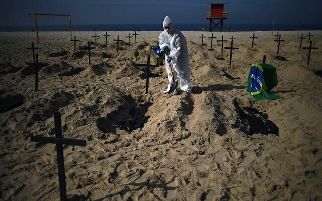 Activists from the Brazilian NGO Rio de Paz (Peace Rio), dig 100 mock graves on Copacabana beach symbolizing deaths from the COVID-19 coronavirus in Rio de Janeiro, Brazil, on June 11, 2020, to protest against Brazil's "bad governance" of the pandemic. (CARL DE SOUZA / AFP) Activists from the Brazilian NGO Rio de Paz (Peace Rio), dig 100 mock graves on Copacabana beach symbolizing deaths from the COVID-19 coronavirus in Rio de Janeiro, Brazil, on June 11, 2020, to protest against Brazil's "bad governance" of the pandemic. (CARL DE SOUZA / AFP)