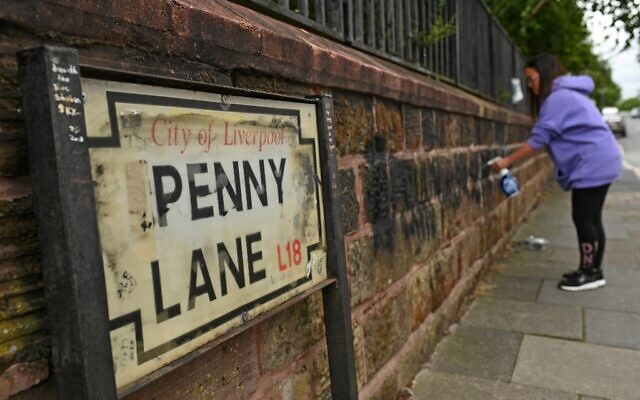 A local resident cleans graffiti from a wall on Penny Lane in Liverpool, north west England on June 12, 2020, after a wall and street signs were defaced (Oli SCARFF / AFP) A local resident cleans graffiti from a wall on Penny Lane in Liverpool, north west England on June 12, 2020, after a wall and street signs were defaced (Oli SCARFF / AFP)