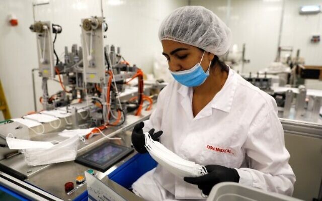A worker at the Sion Medical factory, the country's first production line of N95 masks, produces a mask at the factory in the southern city of Sderot, on June 15, 2020. (MENAHEM KAHANA/AFP) A worker at the Sion Medical factory, the country's first production line of N95 masks, produces a mask at the factory in the southern city of Sderot, on June 15, 2020. (MENAHEM KAHANA/AFP)