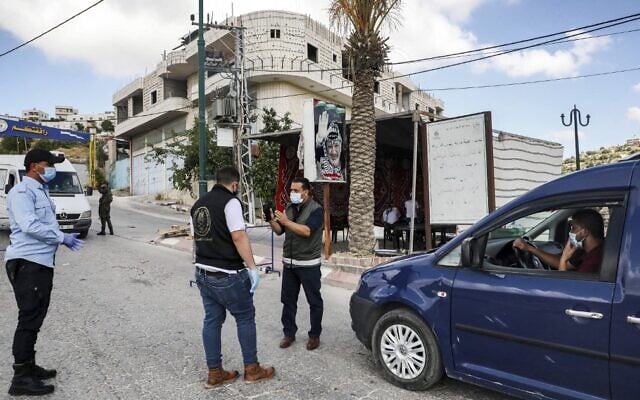 Mask-clad Palestinian security forces stand at a checkpoint in the village of Tafouh, west of Hebron in the West Bank, on June 19, 2020, while enforcing a lockdown due to a surge of new cases of coronavirus (HAZEM BADER / AFP) Mask-clad Palestinian security forces stand at a checkpoint in the village of Tafouh, west of Hebron in the West Bank, on June 19, 2020, while enforcing a lockdown due to a surge of new cases of coronavirus (HAZEM BADER / AFP)