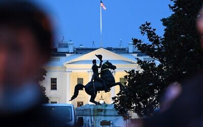A row of police officers stand guard with the equestrian statue of former US President General Andrew Jackson behind, after protesters tried to topple it, at Lafayette square, in front of the White House, in Washington, DC on June 22, 2020 (Eric BARADAT / AFP)