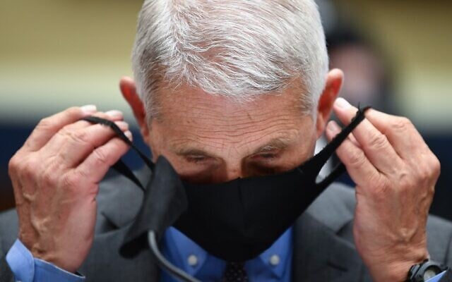 Director of the National Institute for Allergy and Infectious Diseases Dr. Anthony Fauci takes off his face before he testifies before the US Senate Health, Education, Labor, and Pensions Committee hearing to examine COVID-19, on June 23, 2020. (KEVIN DIETSCH / POOL / AFP) Director of the National Institute for Allergy and Infectious Diseases Dr. Anthony Fauci takes off his face before he testifies before the US Senate Health, Education, Labor, and Pensions Committee hearing to examine COVID-19, on June 23, 2020. (KEVIN DIETSCH / POOL / AFP)