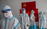 Illustrative: Medics from Beijing Fengsheng Special Hospital of Traditional Medical Traumatology and Orthopaedics prepare for their shift at the Jinrong Street testing site, inside a room where a Communist Party flag and a piece of red tissue with words that reads "Beijing Fengsheng Special Hospital of Traditional Medical Traumatology and Orthopaedics" (back on wall) in Beijing on June 24, 2020. (NICOLAS ASFOURI / AFP)