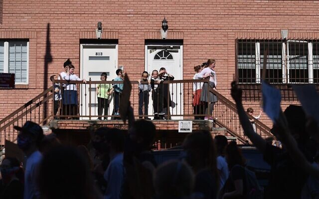 Illustrative: Members of the Orthodox Jewish community watch as protesters walk through the Brooklyn borough on June 3, 2020, during a "Breonna Taylor and Black Lives Matter" protest in New York City, after the recent death in Minneapolis police custody of George Floyd. (Photo by Angela Weiss / AFP) Illustrative: Members of the Orthodox Jewish community watch as protesters walk through the Brooklyn borough on June 3, 2020, during a "Breonna Taylor and Black Lives Matter" protest in New York City, after the recent death in Minneapolis police custody of George Floyd. (Photo by Angela Weiss / AFP)