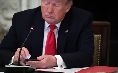 US President Donald Trump on his phone during a roundtable at the State Dining Room of the White House June 18, 2020 in Washington, DC. (Alex Wong/Getty Images/AFP)
