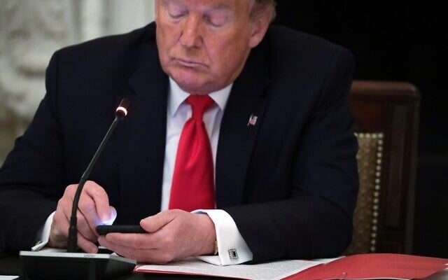 US President Donald Trump on his phone during a roundtable at the State Dining Room of the White House June 18, 2020 in Washington, DC. (Alex Wong/Getty Images/AFP) US President Donald Trump on his phone during a roundtable at the State Dining Room of the White House June 18, 2020 in Washington, DC. (Alex Wong/Getty Images/AFP)