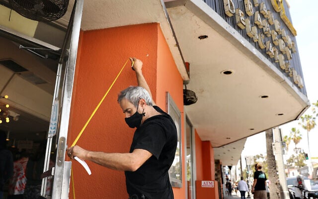 Marc Canter measures in case he needs to board up the doors and windows at Canter's Deli on Fairfax on Sunday, May 31, 2020. (Christina House / Los Angeles Times via Getty Images via JTA) Marc Canter measures in case he needs to board up the doors and windows at Canter's Deli on Fairfax on Sunday, May 31, 2020. (Christina House / Los Angeles Times via Getty Images via JTA)