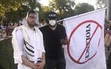 Rabbi Ari Hart, wearing a prayer shawl and face shield, stands with another protester at the interfaith demonstration in memory of George Floyd and protesting systemic racism in Chicago on June 2, 2020. (Courtesy of Hart/ via JTA)