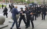 In this image from video provided by WBFO, a Buffalo police officer appears to shove a man who walked up to police Thursday, June 4, 2020, in Buffalo, N.Y. Video from WBFO shows the man appearing to hit his head on the pavement, with blood leaking out as officers walk past to clear Niagara Square.  (Mike Desmond/WBFO via AP)