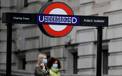 Pedestrians wear masks as they walk near Charing Cross Station in London, Friday, June 5, 2020. It will become compulsory to wear face coverings while using public transport in England from Monday June 15. (AP Photo/Kirsty Wigglesworth)