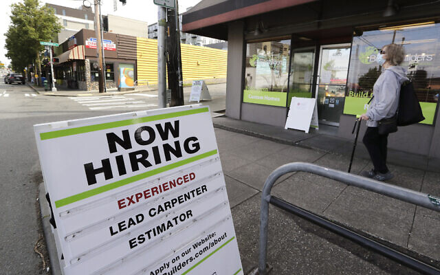 In this photo taken Thursday, June 4, 2020, a pedestrian wearing a mask walks past reader board advertising a job opening for a remodeling company, in Seattle. (AP Photo/Elaine Thompson) In this photo taken Thursday, June 4, 2020, a pedestrian wearing a mask walks past reader board advertising a job opening for a remodeling company, in Seattle. (AP Photo/Elaine Thompson)