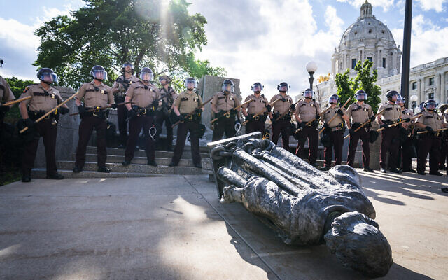 Minnesota State Troopers surrounded the statue of Christopher Columbus after it was toppled in front of the Minnesota State Capitol, June 10, 2020, in St. Paul, Minnesota (Leila Navidi/Star Tribune via AP) Minnesota State Troopers surrounded the statue of Christopher Columbus after it was toppled in front of the Minnesota State Capitol, June 10, 2020, in St. Paul, Minnesota (Leila Navidi/Star Tribune via AP)