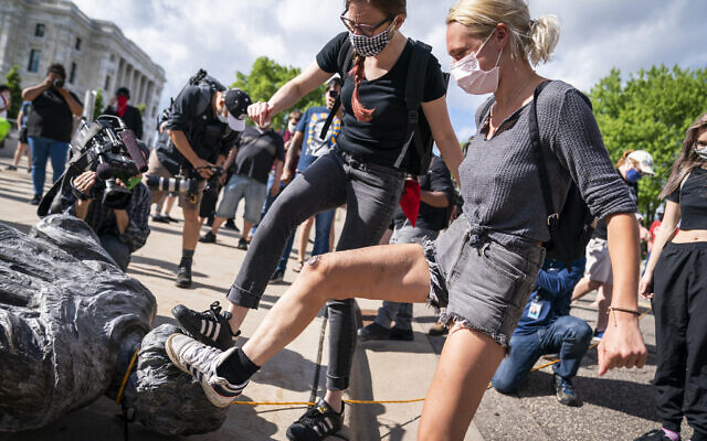 People take turns stomping the Christopher Columbus statue after it was toppled in front of the Minnesota State Capitol in St. Paul, Minn., on Wednesday, June 10, 2020. (Leila Navidi/Star Tribune via AP) People take turns stomping the Christopher Columbus statue after it was toppled in front of the Minnesota State Capitol in St. Paul, Minn., on Wednesday, June 10, 2020. (Leila Navidi/Star Tribune via AP)