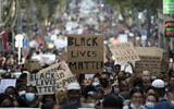 A protester looks up at a sign that reads "Black Lives Matter" in Marseille, southern France, during a protest against the recent death of George Floyd, June 6, 2020. (AP Photo/Daniel Cole, File)