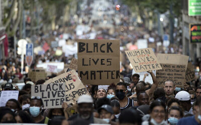 A protester looks up at a sign that reads "Black Lives Matter" in Marseille, southern France, during a protest against the recent death of George Floyd, June 6, 2020. (AP Photo/Daniel Cole, File)
