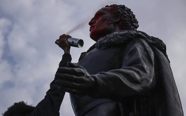 A protester spray paints the face of a statue of Christopher Columbus as a small group of protesters walks through Bayside in Miami on Wednesday, June 10, 2020. (Carl Juste/Miami Herald via AP) A protester spray paints the face of a statue of Christopher Columbus as a small group of protesters walks through Bayside in Miami on Wednesday, June 10, 2020. (Carl Juste/Miami Herald via AP)