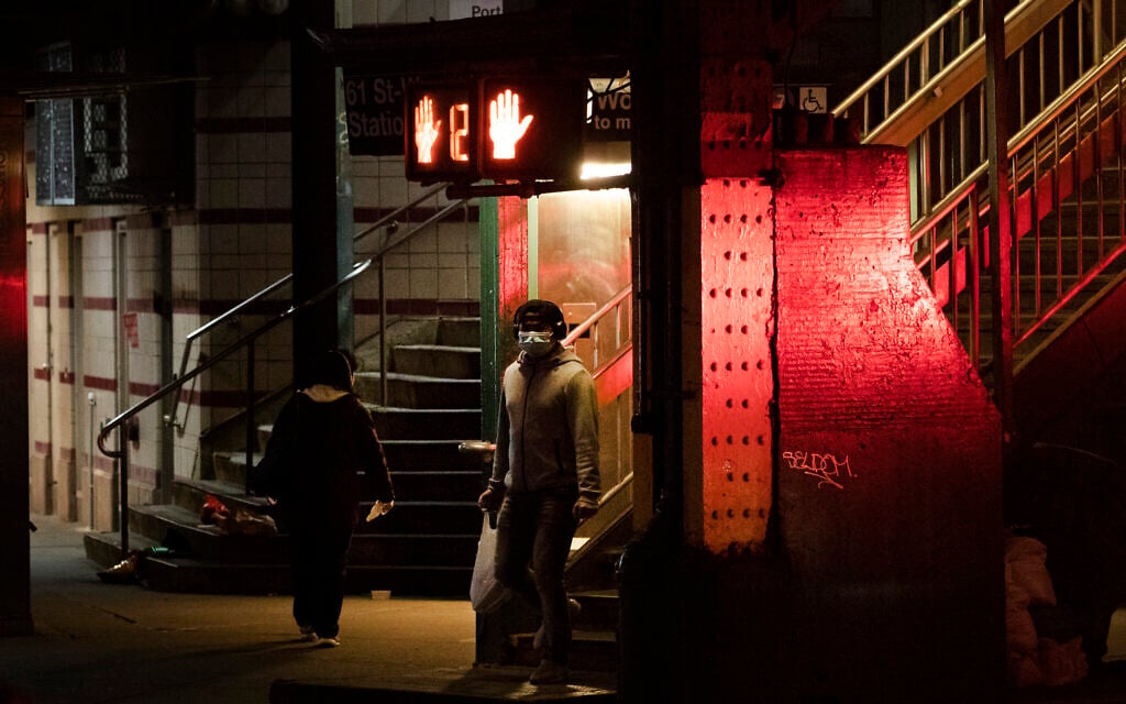 A man walks out of a subway station in the Queens borough of New York, Thursday night, April 23, 2020, during the coronavirus pandemic. (AP Photo/Mark Lennihan)