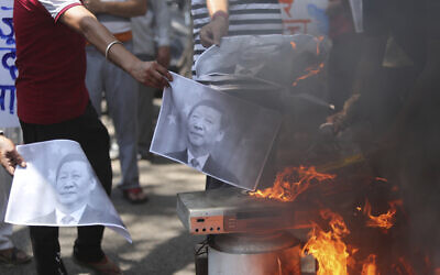 Indians burn photographs of Chinese President Xi Jinping during a protest against the Chinese government in Jammu, India, June 17, 2020. (/Channi Anand/AP)