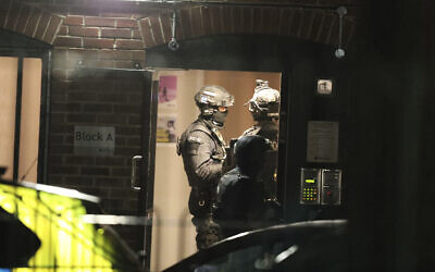 Armed police officers work at a block of flats off Basingstoke Road in Reading after a stabbing attack at Forbury Gardens park in the town center of Reading, England, June 20, 2020. (Steve Parsons/PA via AP)