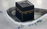 Workers disinfect the ground around the Kaaba, the cubic building at the Grand Mosque, in the Muslim holy city of Mecca, Saudi Arabia, on March 7, 2020. (Amr Nabil/ AP)