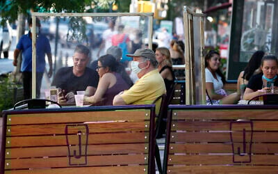 Plastic partitions separate patrons at Jake's Dilemma the first day of the phase two reopening of the city during the current coronavirus outbreak, Monday, June 22, 2020, in New York. In phase two, restaurants are allowed have customers seated for outdoor dining but with some restrictions. (AP Photo/Kathy Willens)