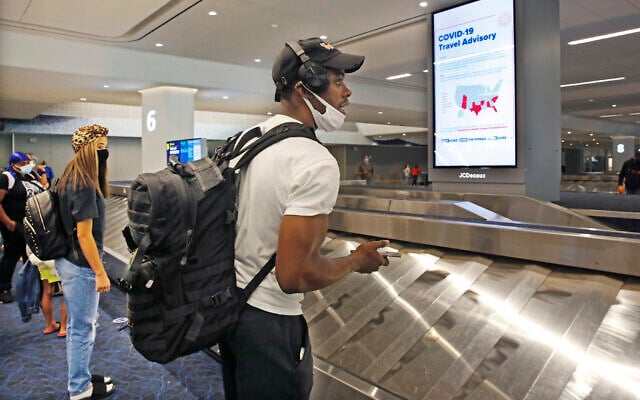 Arriving passengers await their bags in the baggage claim area at LaGuardia Airport's Terminal B baggage claim area, June 25, 2020, in New York. (AP Photo/Kathy Willens) Arriving passengers await their bags in the baggage claim area at LaGuardia Airport's Terminal B baggage claim area, June 25, 2020, in New York. (AP Photo/Kathy Willens)