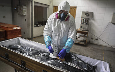 An employee takes the fingerprints of a woman who died from the new coronavirus before her remains are cremated at La Recoleta crematorium in Santiago, Chile, Saturday, June 27, 2020. The Ministry of Health reported on Saturday the highest number of deaths in Chile since the start of the pandemic. (AP Photo/Esteban Felix) An employee takes the fingerprints of a woman who died from the new coronavirus before her remains are cremated at La Recoleta crematorium in Santiago, Chile, Saturday, June 27, 2020. The Ministry of Health reported on Saturday the highest number of deaths in Chile since the start of the pandemic. (AP Photo/Esteban Felix)