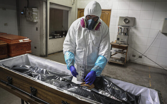 An employee takes the fingerprints of a woman who died from the new coronavirus before her remains are cremated at La Recoleta crematorium in Santiago, Chile, Saturday, June 27, 2020. The Ministry of Health reported on Saturday the highest number of deaths in Chile since the start of the pandemic. (AP Photo/Esteban Felix) An employee takes the fingerprints of a woman who died from the new coronavirus before her remains are cremated at La Recoleta crematorium in Santiago, Chile, Saturday, June 27, 2020. The Ministry of Health reported on Saturday the highest number of deaths in Chile since the start of the pandemic. (AP Photo/Esteban Felix)