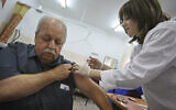 A man receives a swine flu vaccine at a medical center in Jerusalem, December 20, 2009 (AP Photo/Dan Balilty)