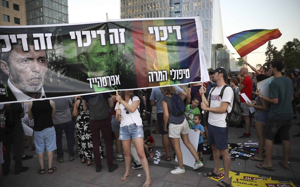 A 2019 rally against gay conversion therapy, with demonstrators holding a sign featuring MK Rafi Peretz and the words 'Oppression is Oppression.' (AP Photo/Oded Balilty)