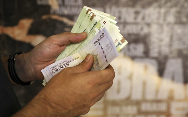 File: A man counts banknotes and traveler checks in Tehran, Iran, August 21, 2019 (AP Photo/Ebrahim Noroozi) File: A man counts banknotes and traveler checks in Tehran, Iran, August 21, 2019 (AP Photo/Ebrahim Noroozi)