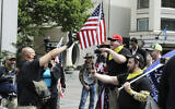 Illustrative -- Members of a group wearing shirts with the logo of the far-right Proud Boys group at right, argue with a counter protester during a small protest against Washington state's stay-at-home orders, May 1, 2020, in downtown Seattle (AP Photo/Ted S. Warren)