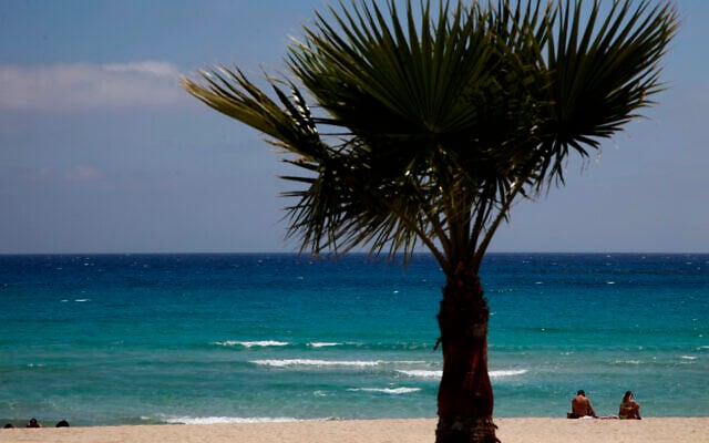 Sunbathers sit on an empty stretch of 'Landa' beach at the Cyprus seaside resort of Ayia Napa, a favorite among tourists, May 10 2020. (Photo/Petros Karadjias) Sunbathers sit on an empty stretch of 'Landa' beach at the Cyprus seaside resort of Ayia Napa, a favorite among tourists, May 10 2020. (Photo/Petros Karadjias)
