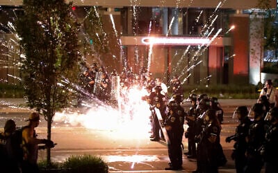 A firework explodes by a police line as demonstrators gather to protest the death of George Floyd, Saturday, May 30, 2020, near the White House in Washington. Floyd died after being restrained by Minneapolis police officers. (AP Photo/Alex Brandon)