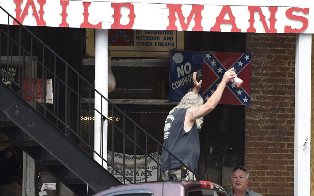 A patron of a Confederate memorabilia store reacts to protesters, Friday, June 5, 2020, in Kennesaw, Georgia. (AP Photo/Mike Stewart)