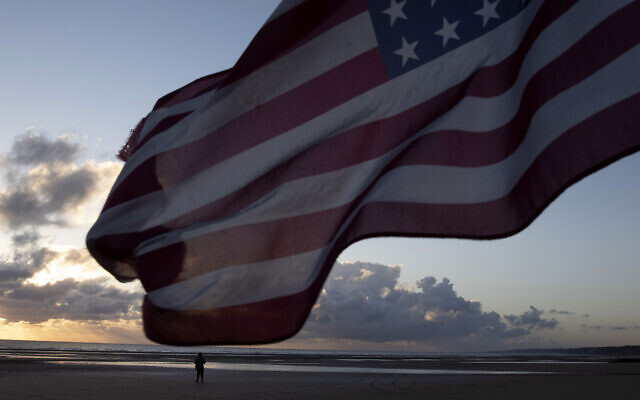 A man in a vintage US WWII uniform walks at sunrise prior to a D-Day 76th anniversary ceremony in Saint Laurent sur Mer, Normandy, France, June 6, 2020 (AP Photo/Virginia Mayo) A man in a vintage US WWII uniform walks at sunrise prior to a D-Day 76th anniversary ceremony in Saint Laurent sur Mer, Normandy, France, June 6, 2020 (AP Photo/Virginia Mayo)
